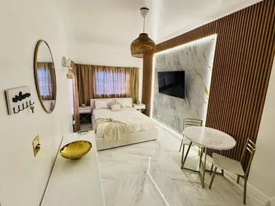 a bedroom with a bed and a table and a mirror at Stylish Studio in Heart of Miami in Miami