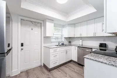 a kitchen with white cabinets and a white door at New Apt 2 Bed 2 Bath with Amazing PATIO in Fort Lauderdale