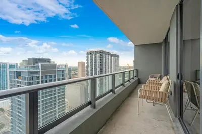 a balcony with two chairs and a view of the city at Sunlit 1BR Condo In Downtown Miami in Miami