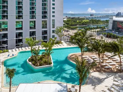 an overhead view of a swimming pool with palm trees at Sunlit 1BR Condo In Downtown Miami in Miami