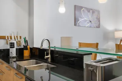 a kitchen with a sink and a glass counter top at Luxury Top-Level Oasis - Oceanfront Views & Resort Perks in Sunny Isles Beach