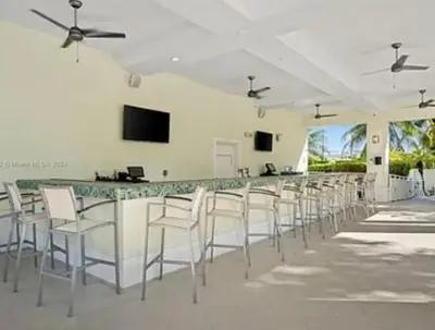 a bar with a row of white chairs in a room at Provident Doral at The Blue in Miami