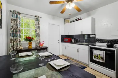 a kitchen with white cabinets and a table with wine glasses at Brickell Stay: Near Beach Downtown Pet-Friendly in Miami