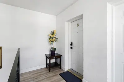 a hallway with a door and a vase of flowers on a table at Little Havana 2BR – Near Brickell Midtown in Miami