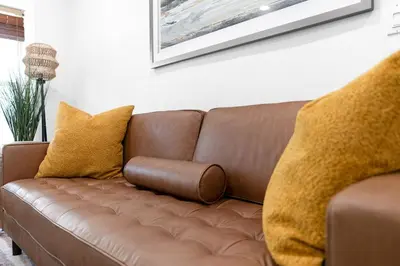 a brown couch with yellow pillows in a living room at Stunning Tropical Pool House Miami Coconut Grove in Miami