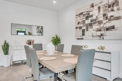 a dining room with a table and chairs at Wonderful New Tropical Pool House North Miami in Gold Coast Heliport