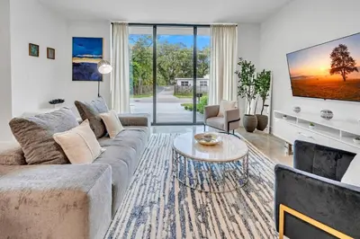 a living room with a couch and a table at Wonderful New Tropical Pool House North Miami in Gold Coast Heliport
