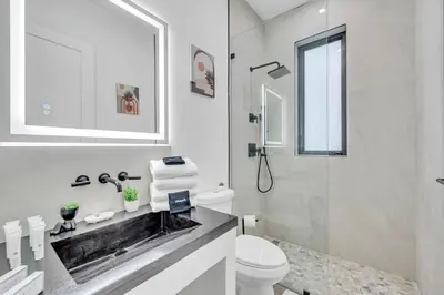 a white bathroom with a sink and a toilet at Stunning Tropical Pool House North Miami in Gold Coast Heliport