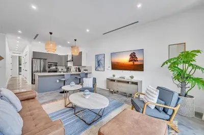 a living room with a couch and a table at Stunning Tropical Pool House North Miami in Gold Coast Heliport