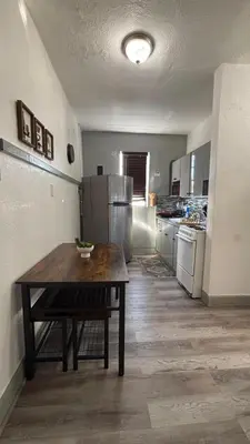 a kitchen with a wooden table and a refrigerator at Noemi's Studio Suite Steps To Marlins Stadium At Little Havana in Miami