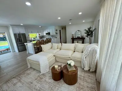 a living room with a white couch and a kitchen at Chic-ness Oasis NOW HEATED POOL ! in Cutler Bay