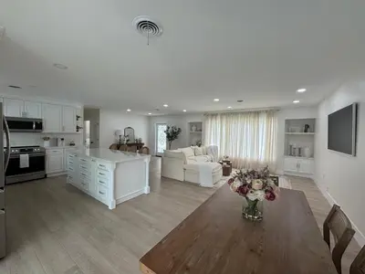 a kitchen and living room with a table and a couch at Chic-ness Oasis NOW HEATED POOL ! in Cutler Bay