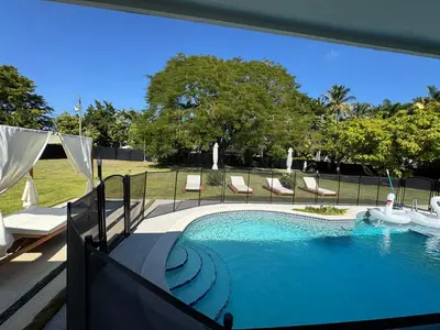 a swimming pool with chairs and a fence around it at Chic-ness Oasis NOW HEATED POOL ! in Cutler Bay