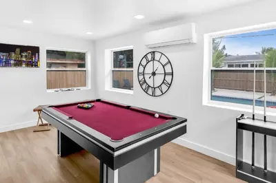 a room with a pool table and a clock at Modern & Cozy Private Pool Home in Parkway Regional Medical Center Heliport