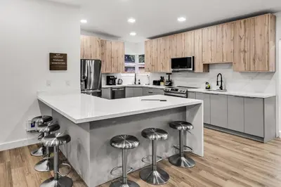 a kitchen with a large island with bar stools at Modern & Cozy Private Pool Home in Parkway Regional Medical Center Heliport