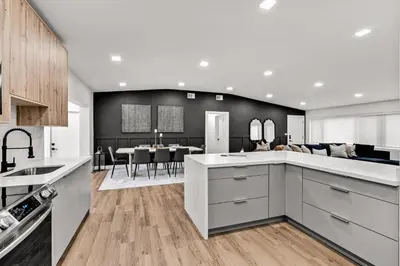 a kitchen with white cabinets and a dining room at Modern & Cozy Private Pool Home in Parkway Regional Medical Center Heliport