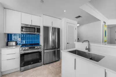 a kitchen with white cabinets and stainless steel appliances at FontaineBleau Suite at Miami Beach in Miami Beach