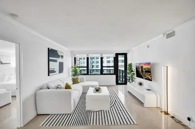 a living room with a white couch and a table at Modern Ocean Escape Stylish 2BR Condo with Resort Amenities Pools Sauna and Gym 1417 in Miami Beach