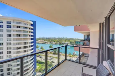an apartment balcony with a view of the water at Modern Ocean Escape Stylish 2BR Condo with Resort Amenities Pools Sauna and Gym 1417 in Miami Beach
