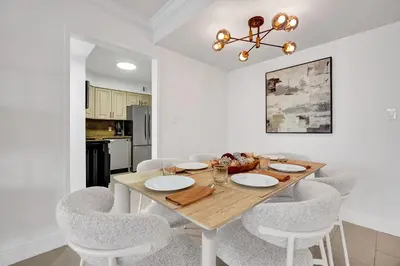 a dining room with a wooden table and chairs at Modern Ocean Escape Stylish 2BR Condo with Resort Amenities Pools Sauna and Gym 1417 in Miami Beach