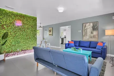 a living room with a blue couch and a green wall at 175 Casa Buena Blanca in Miami