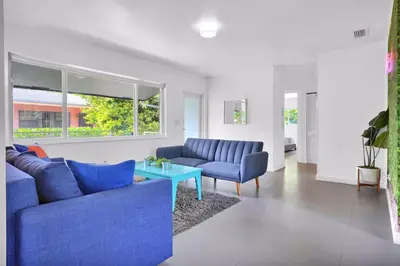 a living room with two blue couches and a table at 175 Casa Buena Blanca in Miami