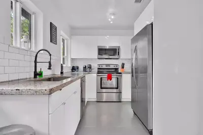 a white kitchen with a stainless steel refrigerator at 175 Casa Buena Blanca in Miami