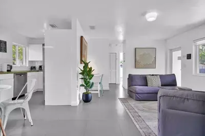 a living room with a purple couch and a kitchen at 175 Casa Buena Blanca in Miami