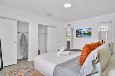 a bedroom with a large white bed with orange pillows at 175 Casa Buena Blanca in Miami
