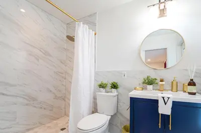 a bathroom with a toilet and a mirror at Top Villa Near Beach with Game Room, Hot Tub and Pool in Pembroke Pines