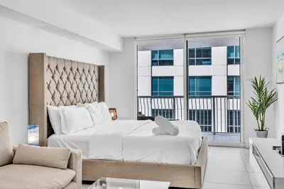 a bedroom with a large bed and a couch at Central Unit in Heart of Brickell in Miami