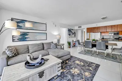 a living room with a gray couch and a kitchen at Spacious 1 Bed 1 BTH Brickell Ocean View in Miami