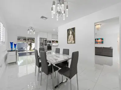 a dining room with a table and black chairs at The Chill Sunny Casa Near Beaches in Miami Lakes
