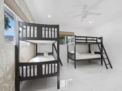 two bunk beds in a room with a ceiling fan at The Chill Sunny Casa Near Beaches in Miami Lakes
