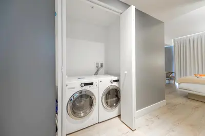a white laundry room with a washer and dryer at Oceanfront Retreat Scenic Views & Coastal Comfort in Hollywood