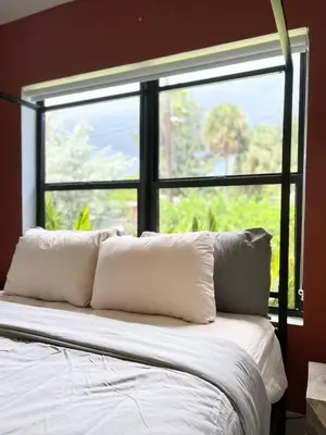 a bed with white pillows in front of a window at Lux Retreat with Pool Near Beach in Fort Lauderdale