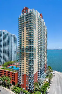 an aerial view of a tall building next to the ocean at Relaxing 1-Bed Condo With City Views in Brickell Key in Miami