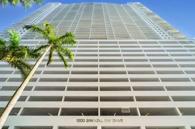 a tall building with a palm tree in front of it at Elegant 1 BR Retreat in Brickell With Free Parking in Miami