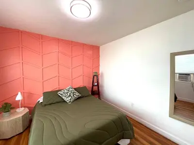 a bedroom with a bed and a pink wall at Apartment in the Heart of Calle 8 with Parking in Miami