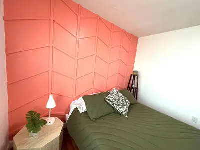 a bedroom with a green bed and a pink wall at Apartment in the Heart of Calle 8 with Parking in Miami
