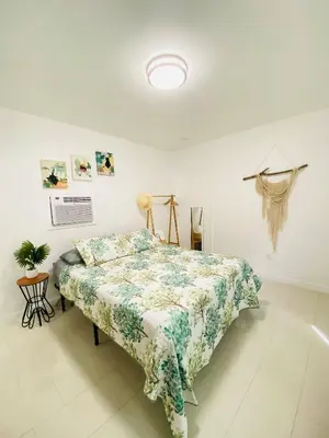 a bedroom with a bed with a floral comforter at Walk to Calle 8 - Authentic Cuban Experience in Miami
