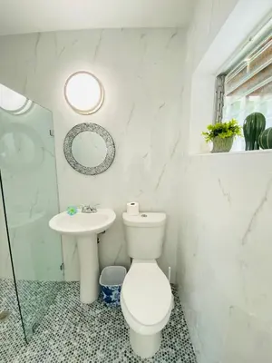 a white bathroom with a toilet and a sink at Walk to Calle 8 - Authentic Cuban Experience in Miami