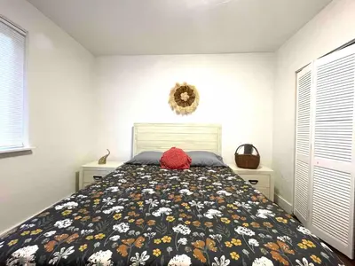 a bedroom with a bed with a flowery comforter at 3 Bedroom Apartment with Backyard Oasis in Miami