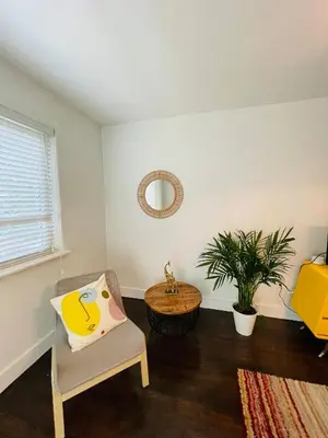 a living room with a chair and a table at 3 Bedroom Apartment with Backyard Oasis in Miami