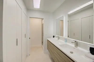 a white bathroom with a sink and a mirror at Waterside retreat in Fort Lauderdale