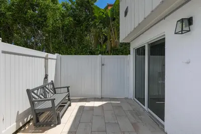 a bench sitting on a patio next to a white fence at Intracostal Beauty in Fort Lauderdale