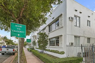 a street sign in front of a white building at Miami Magic 1BR 4 Guests in Miami Beach