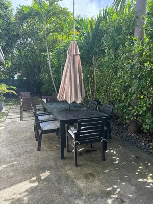 an umbrella sitting on a picnic table with benches at Palace at the Gables in Miami