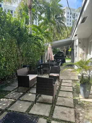 a patio with chairs and tables and a umbrella at Palace at the Gables in Miami