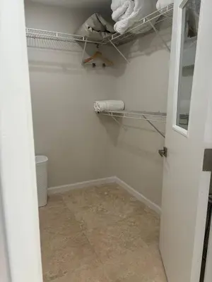 a walk in closet with white walls and a door at Palace at the Gables in Miami